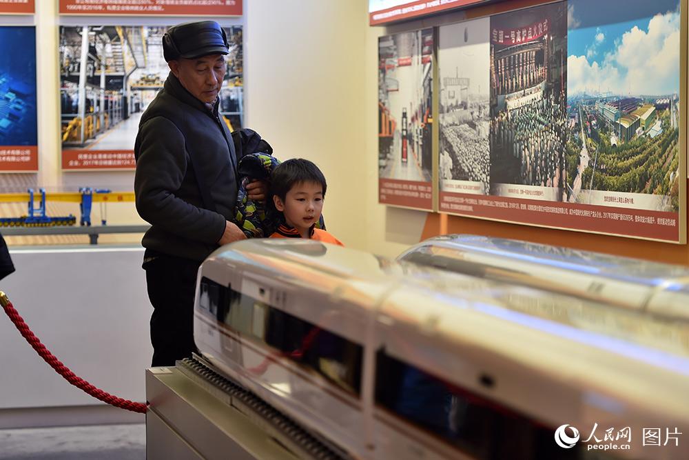 2月1日，小朋友在家人的陪同下，参观和谐号与复兴号列车模型。（人民网记者 翁奇羽 摄）