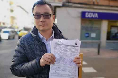 侨胞Enguan Chen在Usera一家BBVA营业厅门前向媒体展示了他的投诉单。